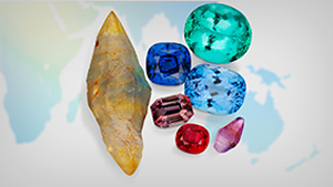 Research Publications An array of rough and polished colored gemstones sitting on a world map.
