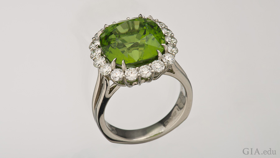 The 10.89 carat peridot in this platinum ring is surrounded by a halo of diamonds, showing off the August birthstone. The 10.89 carat peridot in this platinum ring is surrounded by a halo of diamonds, showing off the August birthstone.