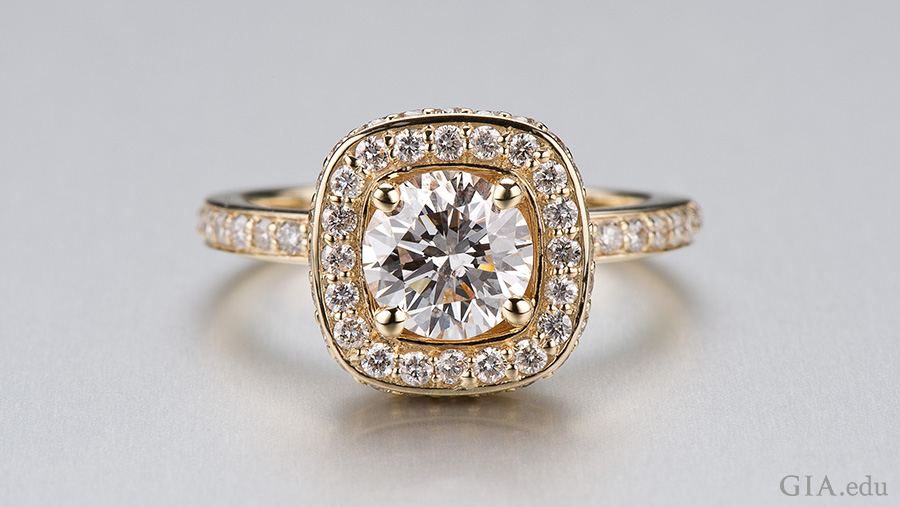 A gold ring designed from a CAD model features the April birthstone with a round center diamond surrounded by small diamonds and a diamond band. A gold ring designed from a CAD model features the April birthstone with a round center diamond surrounded by small diamonds and a diamond band.