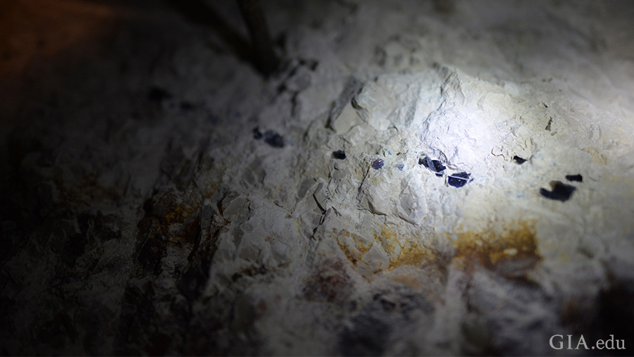 Light shines on the surface of the Lightning Ridge mine where the October birthstone is found, revealing black opal nodules in a line. Light shines on the surface of the Lightning Ridge mine where the October birthstone is found, revealing black opal nodules in a line.