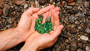 Field gemology Hands holding rough tsavorite in the field