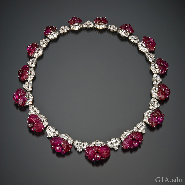 1930’s art deco carved ruby and diamond necklace shows off the July birthstone. Ruby beads are secured to the frame by white metal posts capped with a tiny diamond. 1930’s art deco carved ruby and diamond necklace shows off the July birthstone. Ruby beads are secured to the frame by white metal posts capped with a tiny diamond.