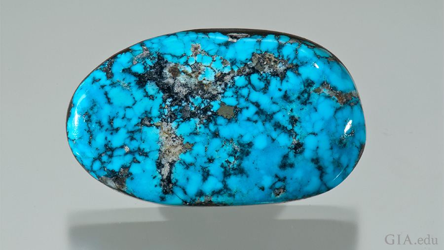This 46.28 carat December birthstone is a medium green blue turquoise free-form cabochon with black specks. This 46.28 carat December birthstone is a medium green blue turquoise free-form cabochon with black specks.
