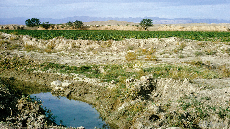 Landscape of a stream running through the terrain with mountains in the distance, near the Nishapur district of Iran where the December birthstone, turquoise, is found. Landscape of a stream running through the terrain with mountains in the distance, near the Nishapur district of Iran where the December birthstone, turquoise, is found.