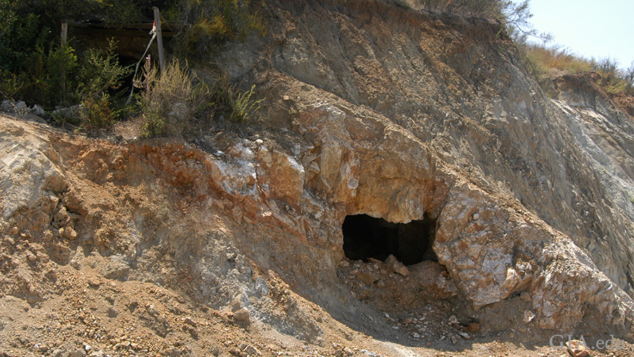 Landscape featuring an old tunnel entrance in a rocky mountain at the Tourmaline King mine where the October birthstone is found. Landscape featuring an old tunnel entrance in a rocky mountain at the Tourmaline King mine where the October birthstone is found.